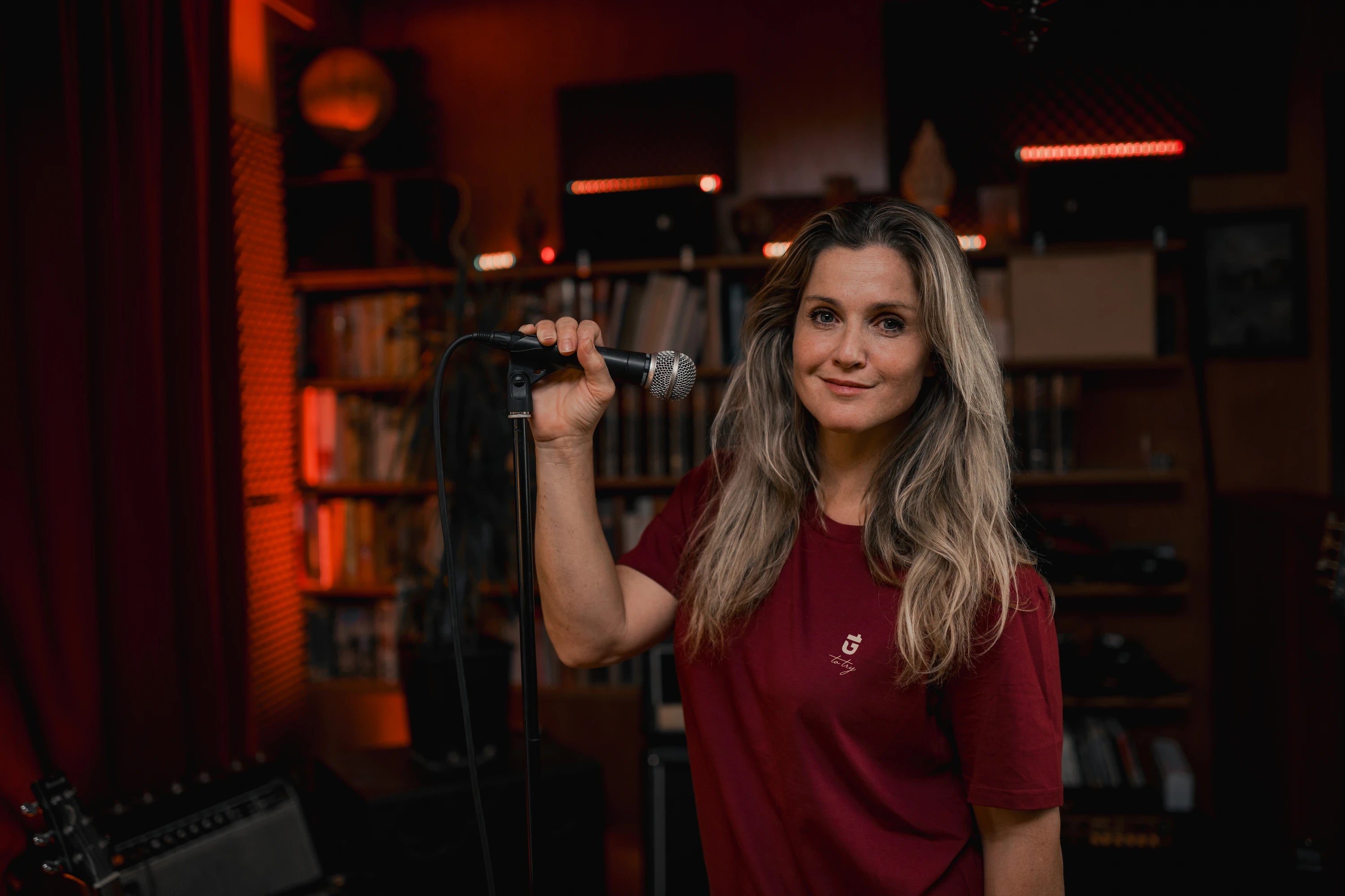 Lizz Görgl steht im Studio am Mikrofon mit Onedare Classic ruby Bio-Baumwolle T-Shirt